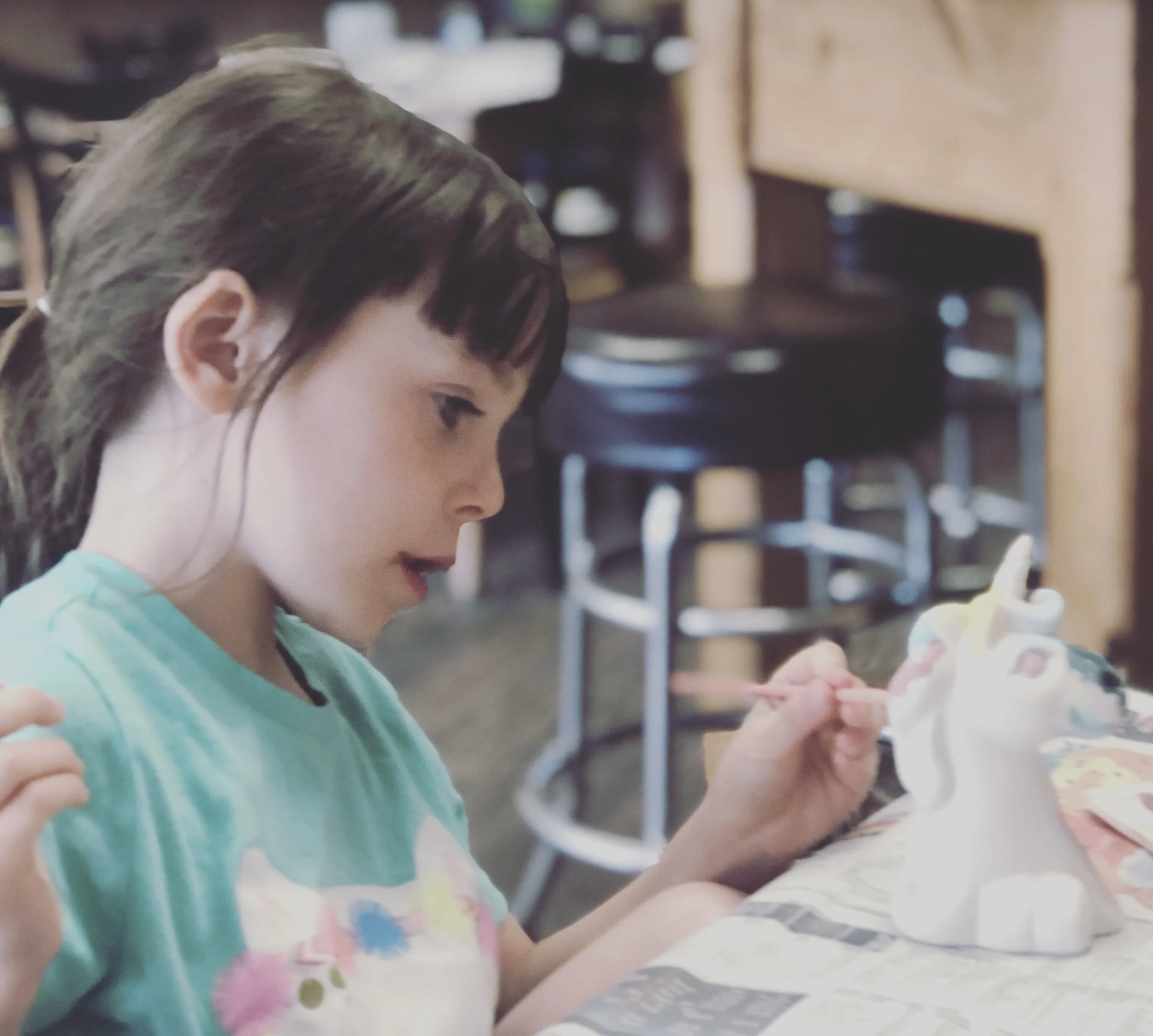 A child painting a ceramic unicorn